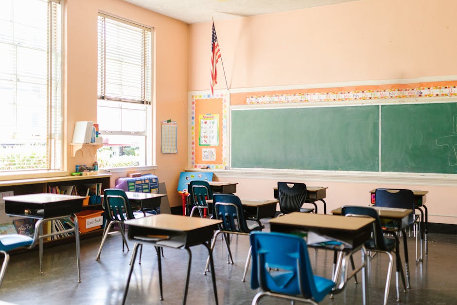 An inviting, sunlit classroom with empty desks and an American flag, ready for students.