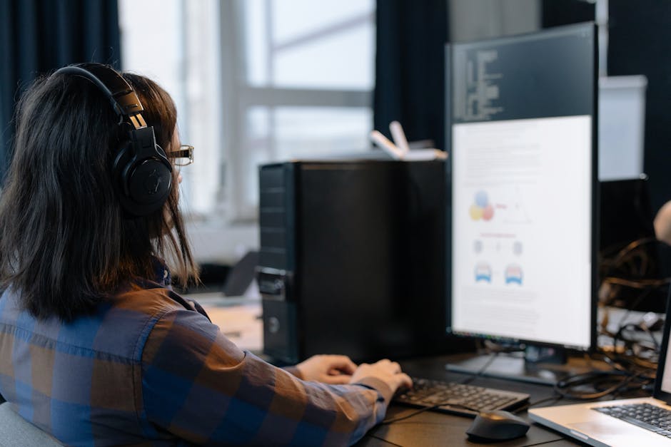 IT professional working on a computer in a modern office setting