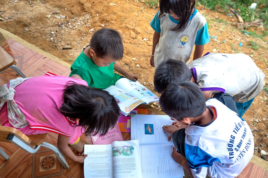 Group of children exploring educational books outdoors, fostering curiosity and learning.