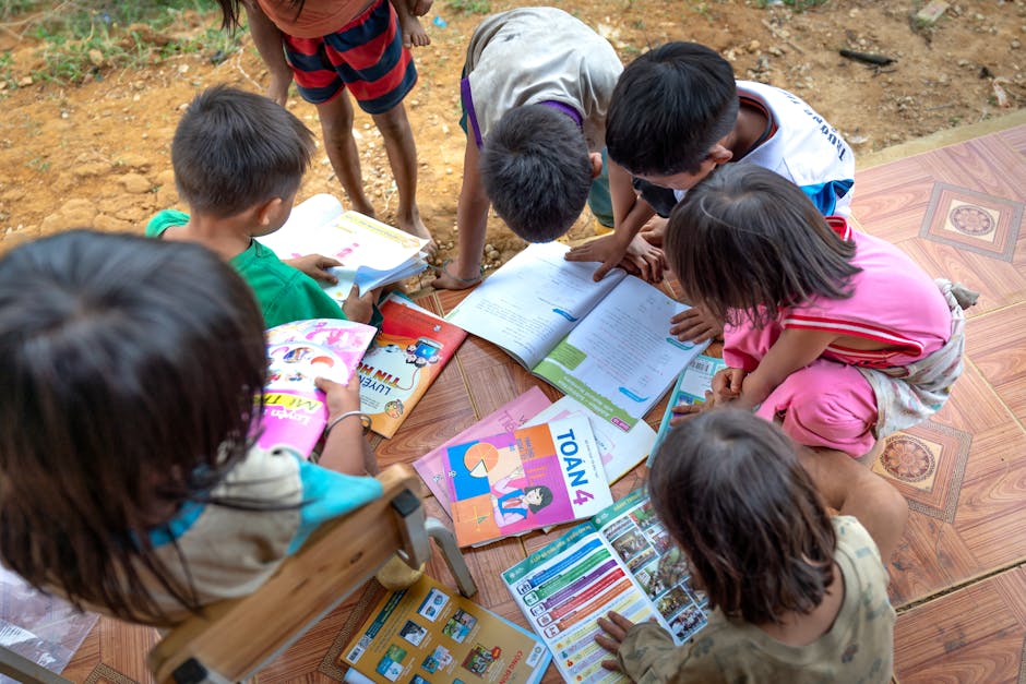 Children gathered outdoors, actively engaged in reading and learning from books.