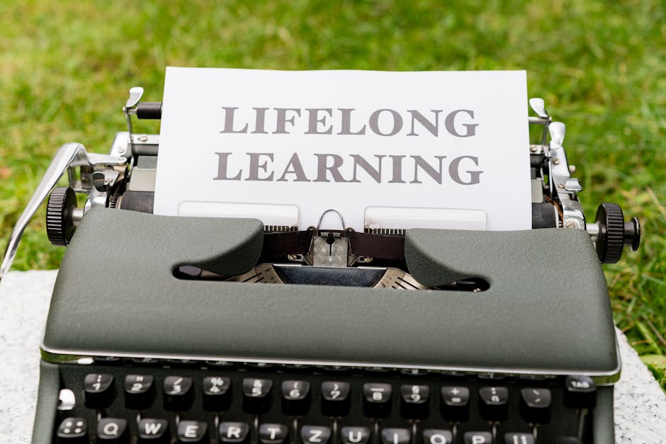 Close-up of a typewriter typing 'Lifelong Learning' outdoors, symbolizing continuous knowledge growth.
